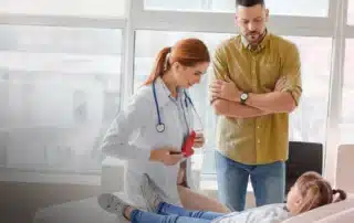 A happy child and parents consult with a friendly doctor in a specialized digestive clinic.